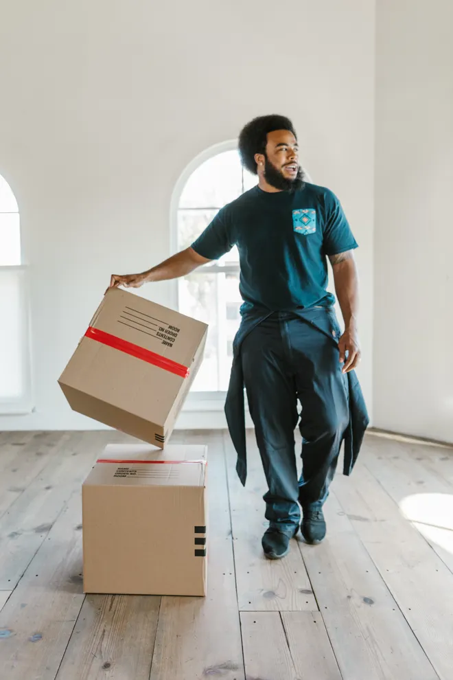 Hauler lifting packed boxes off the floor of an emptied room
